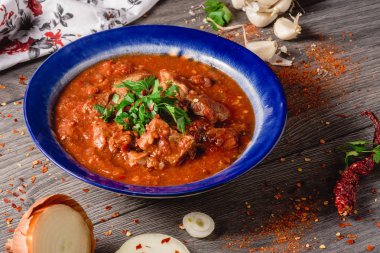 Haşlanmış Dana eti baharat bir domates sos, soğan, sarımsak, biber peper ahşap arka plan üzerinde domates soslu dana eti ile. haşlanmış et ve taze domates yatay görünüm