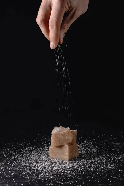 厨师的手洒在佩拉穆希的和平与糖尘, 粉末-Gerogian 传统的甜甜点。用浓缩葡萄汁、玉米和白粉、核桃煮熟的粥。格奥尔基 — 图库照片