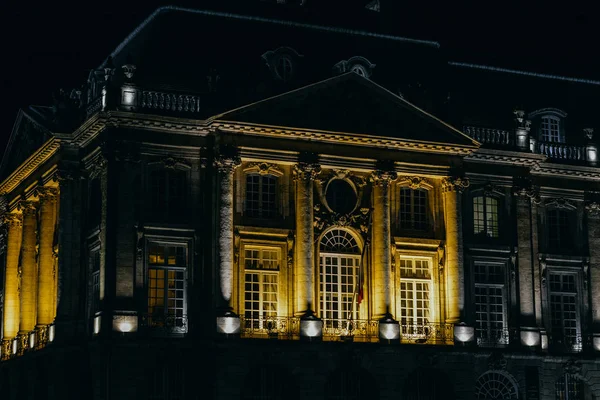 Place de la Bourse en Burdeos, Francia por la noche con reflejo en el espejo de agua y un tranvía que pasa — Foto de Stock