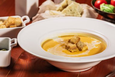 Diyet Vejetaryen kabak kremalı çorba püresi, beyaz şarap, kabak çekirdeği, peynir ve kruton, kahverengi ahşap tablo, yakın çekim.