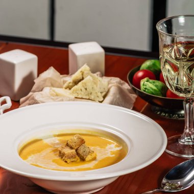 Kabak kremalı çorba kruton, pişmiş nohut, susam, kahverengi ahşap zemin üzerine maydanoz ile. Pişmiş nohut baharatlar ile. Yararlı diyet aperatifler. Beyaz şarap ve peynir ile servis