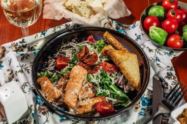 Zarif restoran plaka üzerinde ızgara somon ile Sezar salatası. Beyaz şarap ile servis. Salat kırmızı balık fileto, kraker, Cherry Domates, marul yaprakları, Sezar sos ve Parmesan peyniri