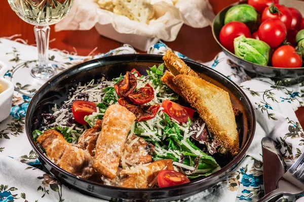 Salada Caesar com Salmão grelhado na elegante placa de restaurante. Servido com vinho branco. Salat com filé de peixe vermelho, bolachas, tomate cereja, folhas de alface, molho Caesar e queijo parmesão — Fotografia de Stock