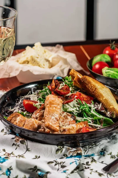 Salada Caesar com Salmão grelhado na elegante placa de restaurante. Servido com vinho branco. Salat com filé de peixe vermelho, bolachas, tomate cereja, folhas de alface, molho Caesar e queijo parmesão — Fotografia de Stock