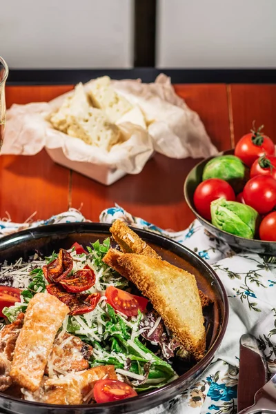 Salada Caesar com Salmão grelhado na elegante placa de restaurante. Servido com vinho branco. Salat com filé de peixe vermelho, bolachas, tomate cereja, folhas de alface, molho Caesar e queijo parmesão — Fotografia de Stock