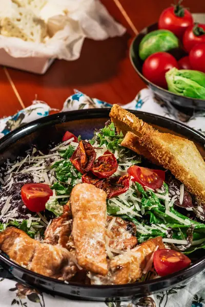 Салат Цезарь с лососем. Подается с белым вином. Салат с филе красной рыбы, соус цезаря, гренки, салат, помидор черри, крупным планом . — стоковое фото