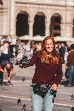 Mutlu traveler kız Milan City. Milan, İtalya, Avrupa'nın Duomo cathedral yakınındaki güvercinler ile poz turist kadın