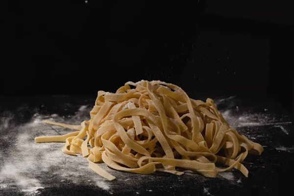 Fresh italian uncooked homemade pasta. Hands making pasta. Spaghetti. Fresh italian spaghetti. Closeup of process of making cooking homemade pasta. Chef make fresh italian traditional pasta