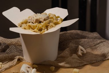 Ev yapımı Makarna, Erişte, fettuccine Alfredo veya Bolognese ahşap bir arka plan üzerinde beyaz bir kutu içinde uzak almak için yakın çekim. logo veya kopyala yapıştır metni için yer