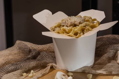 Ev yapımı Makarna, Erişte, fettuccine Alfredo veya Bolognese ahşap bir arka plan üzerinde beyaz bir kutu içinde uzak almak için yakın çekim. logo veya kopyala yapıştır metni için yer