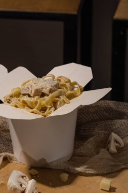 Ev yapımı Makarna, Erişte, fettuccine Alfredo veya Bolognese ahşap bir arka plan üzerinde beyaz bir kutu içinde uzak almak için yakın çekim. logo veya kopyala yapıştır metni için yer