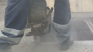 Bir işçi bir açı değirmeni kanalizasyon kapağı üzerinde kullanarak görüntüleri.