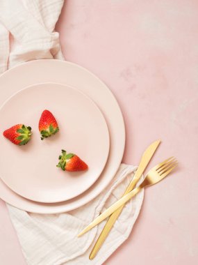 Çilek ile seramik plakalar üstten görünüm pembe pastel zemin üzerine