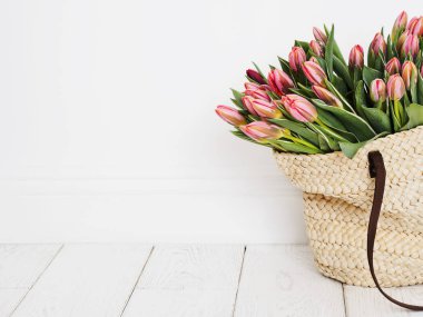 Beyaz arka plan üzerinde taze Pembe lale grup ile hasır çanta