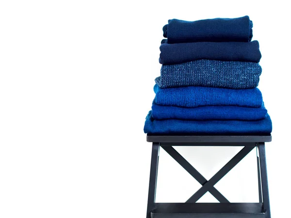 Montón Suéter Lana Azul Sobre Taburete Madera Sobre Fondo Blanco — Foto de Stock