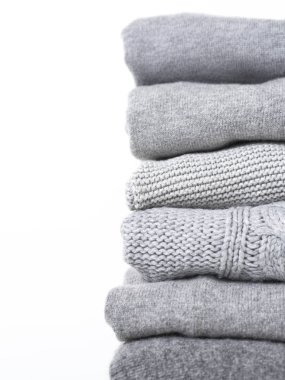 Beyaz arka planda gri yün ve kaşmir kazak dikkat et yığını