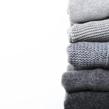 Beyaz arka planda gri yün ve kaşmir kazak dikkat et yığını
