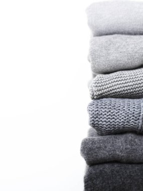 Beyaz arka planda gri yün ve kaşmir kazak dikkat et yığını