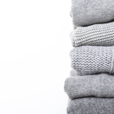 Beyaz arka planda gri yün ve kaşmir kazak dikkat et yığını