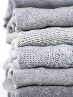 Beyaz arka planda gri yün ve kaşmir kazak dikkat et yığını