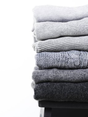 Beyaz arka planda gri yün ve kaşmir kazak dikkat et yığını