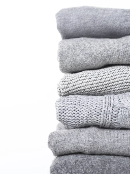 Beyaz arka planda gri yün ve kaşmir kazak dikkat et yığını