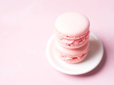 Yığını Fransız çilek kurabiye tabağı üzerinde pembe pastel arka plan üzerinde
