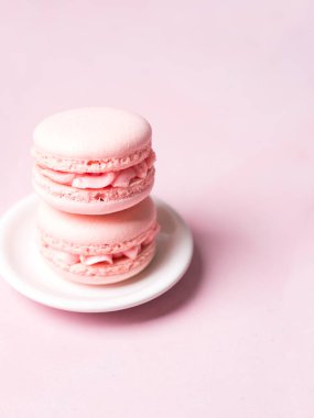 Yığını Fransız çilek kurabiye tabağı üzerinde pembe pastel arka plan üzerinde