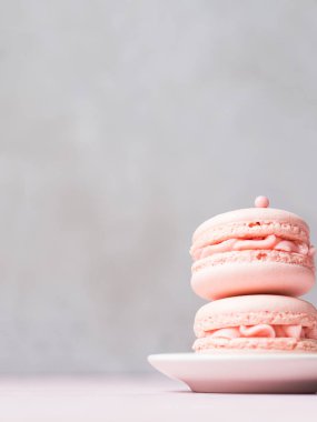 Çift taze çilek macaroons taş üzerinde uçan daire üzerinde arka plan gri