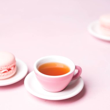 Pastel pembe üzerinde taze çilek macaroons ile servis çay görünümü Kapat