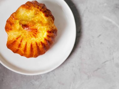 Gri arka plan üzerinde beyaz tabakta servis muhallebi ile lezzetli profiterol üstten görünüm