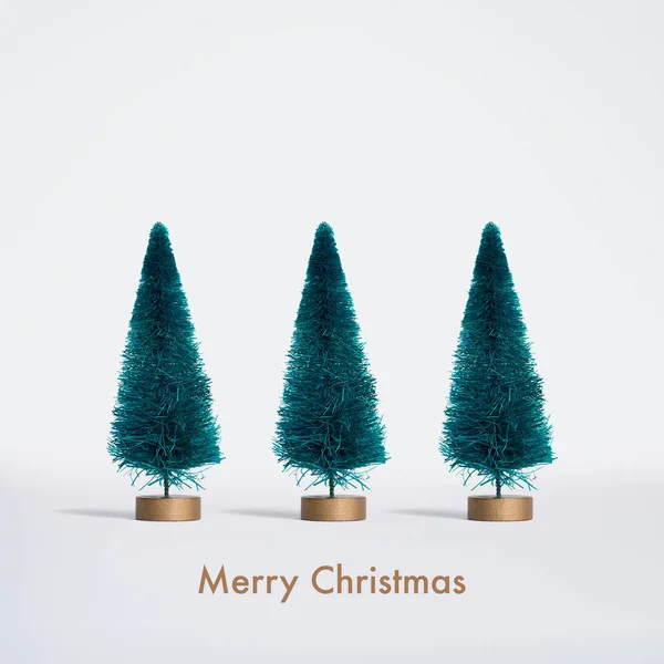 Kleine Kunstmatige Kerstbomen Witte Achtergrond Met Merry Christmas Belettering Witte — Stockfoto