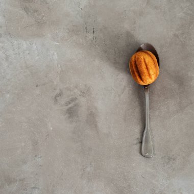 Beton zemin üzerine vintage kaşık üzerinde ceviz ile yoğunlaştırılmış süt şeklinde çerezinin üstten görünüm