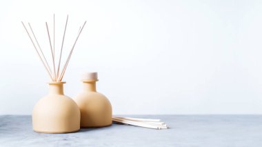 aroma reed fragrance diffusers with rattan sticks on light grey background clipart