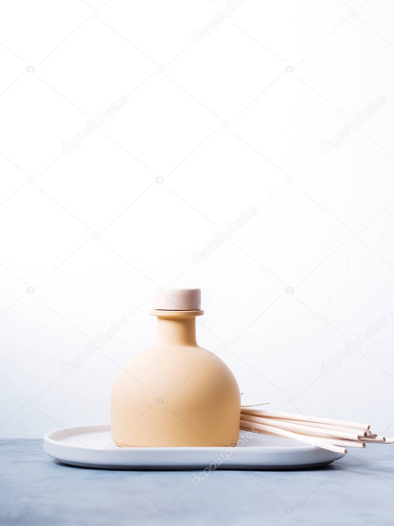 aroma reed fragrance diffuser with rattan sticks on light grey background
