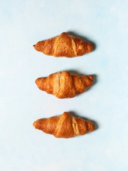 Fila Croissants Recién Horneados Sobre Fondo Azul Pastel — Foto de Stock