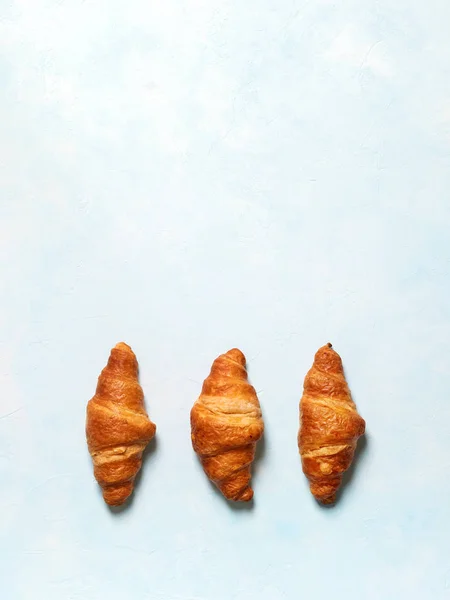 Fila Croissants Recién Horneados Sobre Fondo Azul Pastel — Foto de Stock