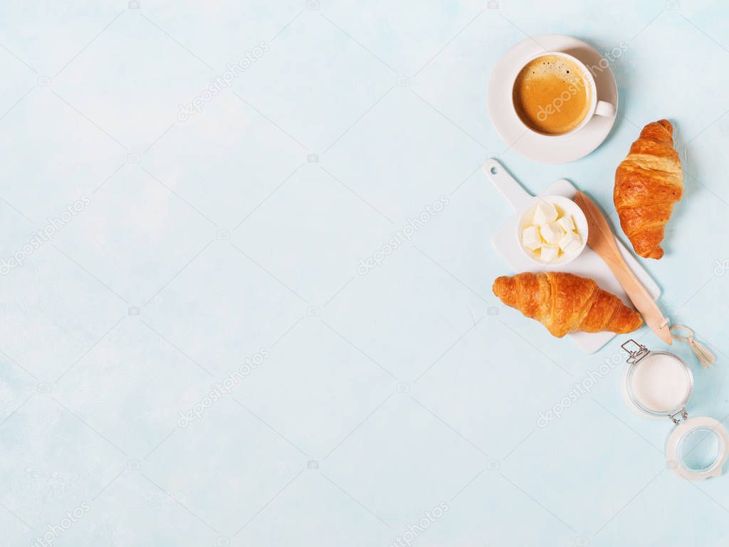 Cup of espresso with capsules, croissants and butter on blue pastel background 