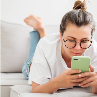 Genç kadının evde smartphone kullanarak gözlük görünümü Kapat