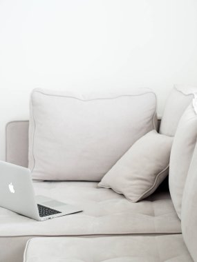 Gri kanepeye, minimalist tarzı yalan açık gümüş dizüstü 
