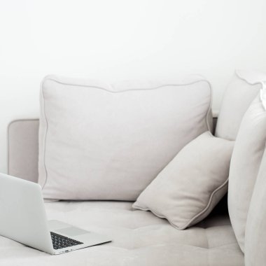 Gri kanepeye, minimalist tarzı yalan açık gümüş dizüstü 