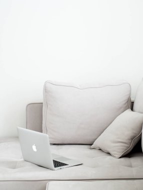 Gri kanepeye, minimalist tarzı yalan açık gümüş dizüstü 