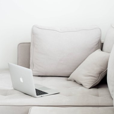 Gri kanepeye, minimalist tarzı yalan açık gümüş dizüstü 
