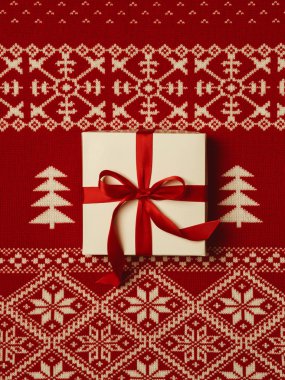 Hediye kutusu Noel süsleme ile yaratıcı arka plan üzerinde kırmızı kurdele ile üstten görünüm 