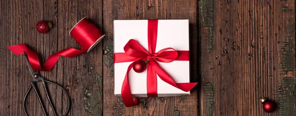Белая Коробка Украшена Красной Лентой Красными Рождественскими Шарами Ножницами Оберточной — стоковое фото