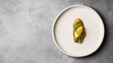 Tam tahıllı ekmek, yumurta ve ayçiçeği tohumu ve seramik beyaz gri beton arka plan, üstten görünüm, diyet gıda kavramı, üzerinde gluten-Alerjik tabakta serpilir siyah tuz taze mini otlar ile avokado kaplama   