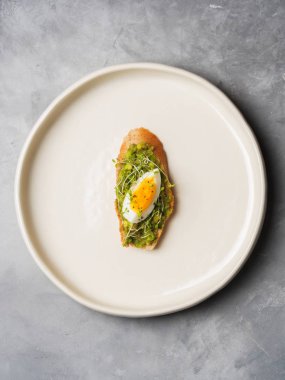 Tam tahıllı ekmek, yumurta ve ayçiçeği tohumu ve seramik beyaz gri beton arka plan, üstten görünüm, diyet gıda kavramı, üzerinde gluten-Alerjik tabakta serpilir siyah tuz taze mini otlar ile avokado kaplama   