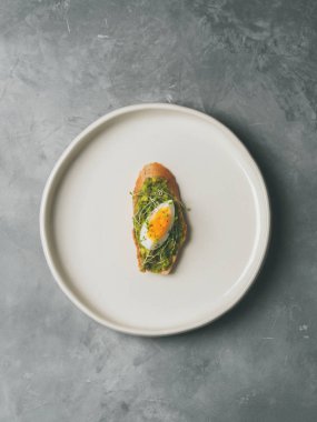 Tam tahıllı ekmek, yumurta ve ayçiçeği tohumu ve seramik beyaz gri beton arka plan, üstten görünüm, diyet gıda kavramı, üzerinde gluten-Alerjik tabakta serpilir siyah tuz taze mini otlar ile avokado kaplama   