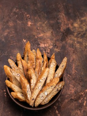 Geleneksel İtalyan badem bisküvi kurabiye ahşap kase üstten görünüm koyu bakır arka plan üzerinde