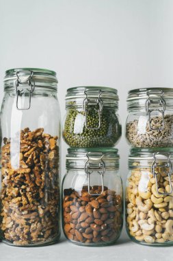 kavanozları kuru kaju fıstığı, badem, ceviz, fıstık, mung fasulye, ışık arka plan ayçiçeği tohumu ile